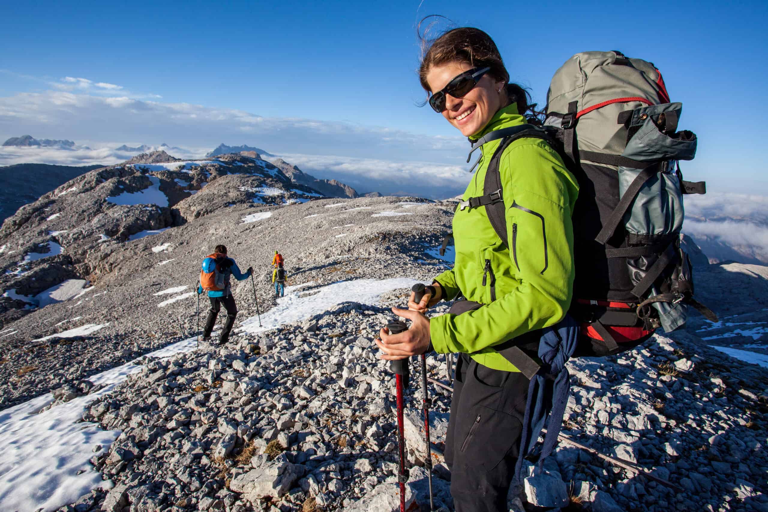 Female hiker on top of a snow capped mountain